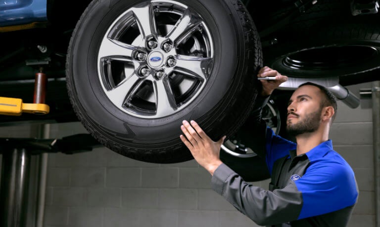 Ford technician checking a tire
